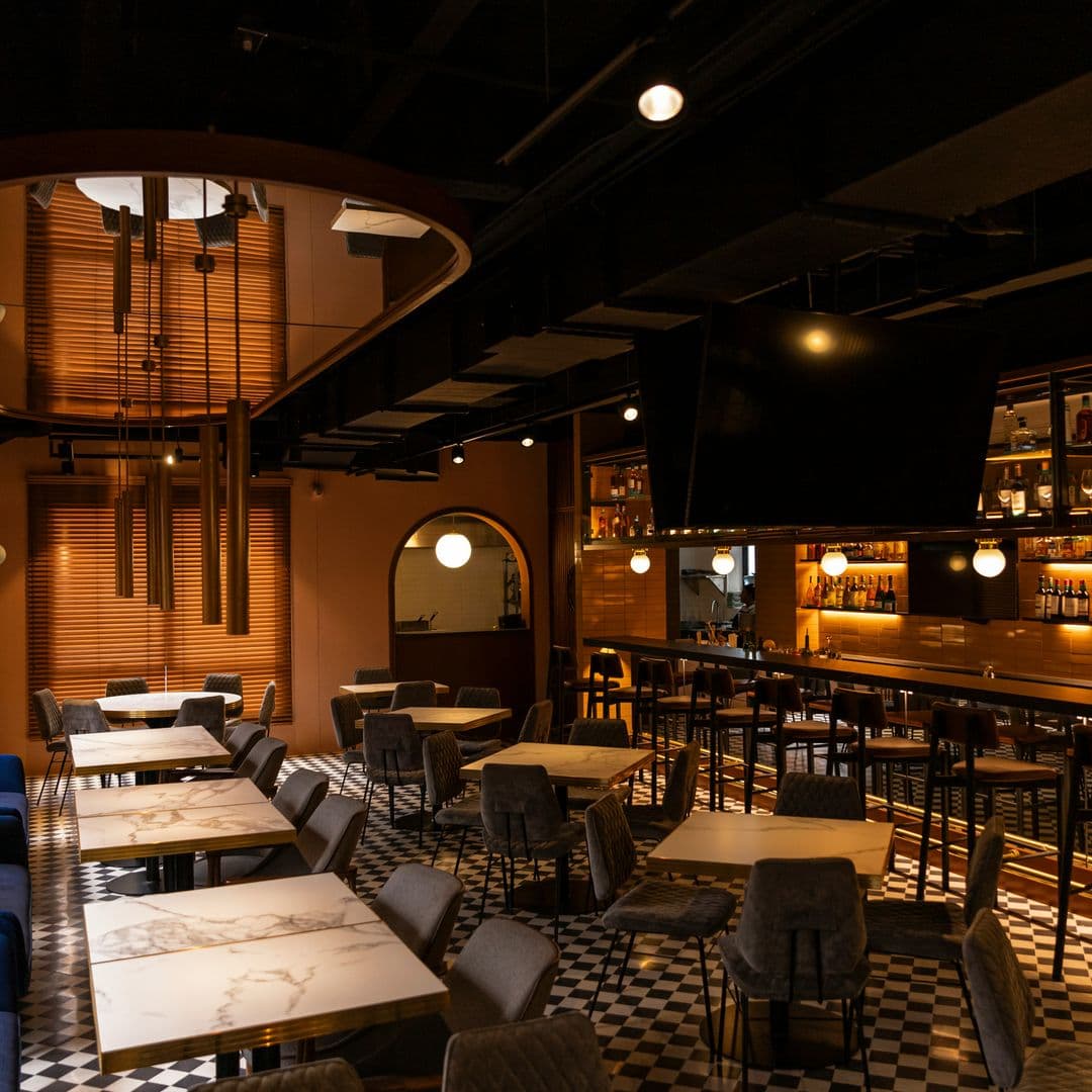 Dunkles Restaurant mit Marmortischen in Weiß